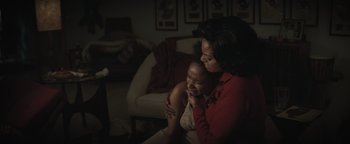 Movie still from “Respect” (2021), directed by Liesl Tommy – Two women sitting in a living room one is holding the arm of the other; Medium shot, Over the shoulder angle