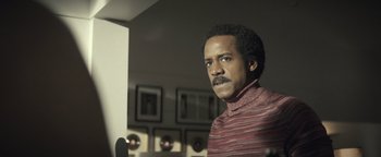 Movie still from “Respect” (2021), directed by Liesl Tommy – A man in a striped shirt is standing in a room; Close Up shot, Low angle