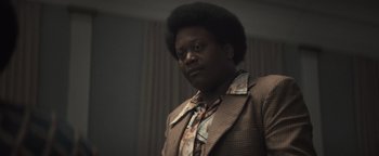 Movie still from “Respect” (2021), directed by Liesl Tommy – A man in a suit and tie looking at the camera; Close Up shot, Low angle