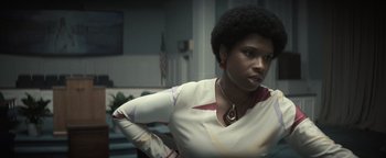 Movie still from “Respect” (2021), directed by Liesl Tommy – A black woman with afro hair standing in a room; Close Up shot, Over the shoulder angle