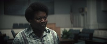 Movie still from “Respect” (2021), directed by Liesl Tommy – A man in a plaid shirt is looking to his left; Close Up shot, Over the shoulder angle