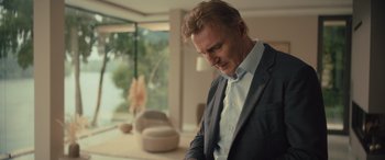 Movie still from “Retribution” (2023), directed by Nimród Antal – A person wearing a suit and tie; Medium shot, Low angle