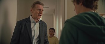 Movie still from “Retribution” (2023), directed by Nimród Antal – A man in a suit talking to a woman and a girl; Medium shot, Over the shoulder angle