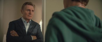 Movie still from “Retribution” (2023), directed by Nimród Antal – A man standing in front of a mirror with his arms crossed; Close Up shot, Over the shoulder angle