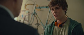 Movie still from “Retribution” (2023), directed by Nimród Antal – A young man with headphones standing in front of a bicycle; Close Up shot, Over the shoulder angle