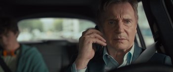 Movie still from “Retribution” (2023), directed by Nimród Antal – A man talking on a cell phone while sitting in a car; Close Up shot, Low angle
