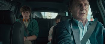 Movie still from “Retribution” (2023), directed by Nimród Antal – Three people are sitting in the back of a car; Close Up shot, Over the shoulder angle