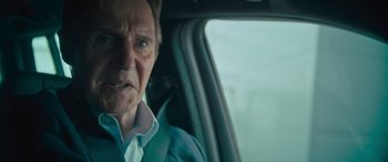 Movie still from “Retribution” (2023), directed by Nimród Antal – An older man sitting in the back seat of a car; Close Up shot, Low angle