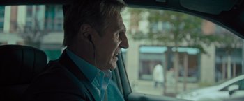 Movie still from “Retribution” (2023), directed by Nimród Antal – A man wearing headphones in a car looking out of the window; Close Up shot, Over the shoulder angle