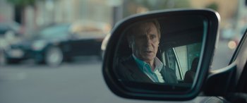 Movie still from “Retribution” (2023), directed by Nimród Antal – A reflection of a man in the side view mirror of a car; Close Up shot, Over the shoulder angle