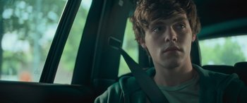 Movie still from “Retribution” (2023), directed by Nimród Antal – A man sitting in the passenger seat of a car; Close Up shot, Low angle