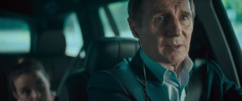 Movie still from “Retribution” (2023), directed by Nimród Antal – An older man wearing headphones in a car; Close Up shot, Over the shoulder angle