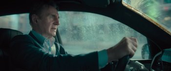 Movie still from “Retribution” (2023), directed by Nimród Antal – A man in a suit driving a car in the rain; Close Up shot, Over the shoulder angle