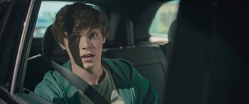 Movie still from “Retribution” (2023), directed by Nimród Antal – A young man sitting in the back seat of a car; Close Up shot, Over the shoulder angle