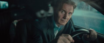 Movie still from “Retribution” (2023), directed by Nimród Antal – A man in a suit and tie looking at a cell phone; Close Up shot, Over the shoulder angle