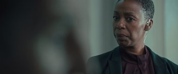 Movie still from “Retribution” (2023), directed by Nimród Antal – A woman in a suit and tie looking at the camera; Close Up shot, Over the shoulder angle