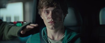 Movie still from “Retribution” (2023), directed by Nimród Antal – A young man in a green jacket with blood all over his face; Close Up shot, Over the shoulder angle