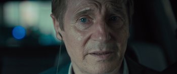 Movie still from “Retribution” (2023), directed by Nimród Antal – An older man with a piercing in his ear stares into the camera; Close Up shot, Over the shoulder angle