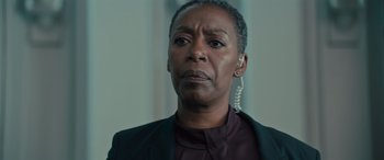 Movie still from “Retribution” (2023), directed by Nimród Antal – An older black woman wearing a jacket and a purple shirt; Close Up shot, Low angle
