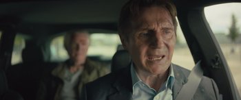 Movie still from “Retribution” (2023), directed by Nimród Antal – A man in a suit in the back of a car; Close Up shot, Over the shoulder angle