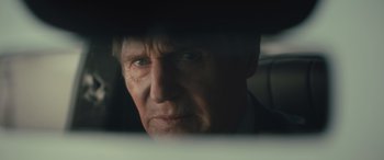 Movie still from “Retribution” (2023), directed by Nimród Antal – A person in a suit looking out a car window; Close Up shot, Over the shoulder angle