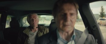 Movie still from “Retribution” (2023), directed by Nimród Antal – Two older men sitting in the back seat of a car; Close Up shot, Over the shoulder angle