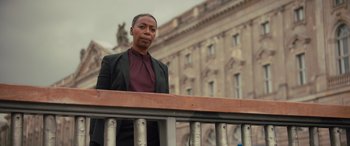 Movie still from “Retribution” (2023), directed by Nimród Antal – A woman standing on top of a wooden railing; Medium shot, Low angle