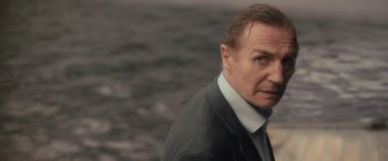 Movie still from “Retribution” (2023), directed by Nimród Antal – A person wearing a suit and tie; Close Up shot, Over the shoulder angle