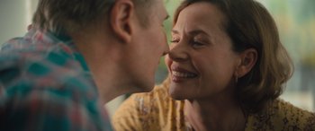 Movie still from “Retribution” (2023), directed by Nimród Antal – A man and a woman are smiling at each other; Close Up shot, Over the shoulder angle