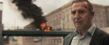 Movie still from “Retribution” (2023), directed by Nimród Antal – A person wearing a suit and tie; Close Up shot, Low angle