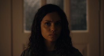 Movie still from “Barbarian” (2022), directed by Zach Cregger – A person with long curly hair; Close Up shot, Low angle