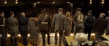 Movie still from “Revolutionary Road” (2008), directed by Sam Mendes – A group of people standing in front of an audience; Wide shot, High angle