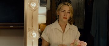 Movie still from “Revolutionary Road” (2008), directed by Sam Mendes – A woman in a white shirt looking at a mirror; Close Up shot, Over the shoulder angle