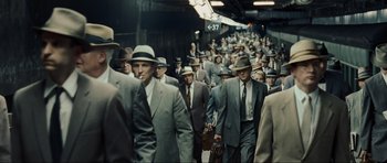 Movie still from “Revolutionary Road” (2008), directed by Sam Mendes – A group of men in suits and hats walking down a street; Wide shot, High angle