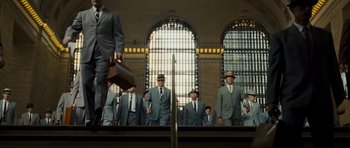 Movie still from “Revolutionary Road” (2008), directed by Sam Mendes – A group of men in suits standing in front of a window; Wide shot, Low angle
