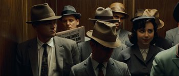 Movie still from “Revolutionary Road” (2008), directed by Sam Mendes – A group of men in suits and fedora hats standing next to each other; Medium shot, Low angle