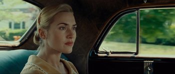 Movie still from “Revolutionary Road” (2008), directed by Sam Mendes – A woman sitting in the passenger seat of a car looking out the window; Close Up shot, Over the shoulder angle