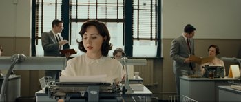 Movie still from “Revolutionary Road” (2008), directed by Sam Mendes – A woman sitting in front of a typewriter in front of a window; Medium shot, Over the shoulder angle