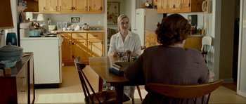 Movie still from “Revolutionary Road” (2008), directed by Sam Mendes – Two women are sitting at a table in a kitchen; Medium shot, Over the shoulder angle