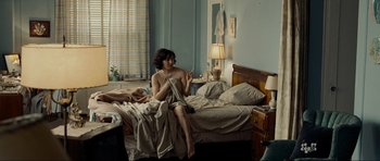 Movie still from “Revolutionary Road” (2008), directed by Sam Mendes – A woman sitting on a bed while holding a cell phone to her ear; Wide shot, High angle