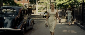 Movie still from “Revolutionary Road” (2008), directed by Sam Mendes – A woman walking down the street in a white dress; Medium shot, Over the shoulder angle