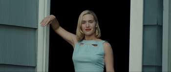 Movie still from “Revolutionary Road” (2008), directed by Sam Mendes – A woman in a light blue dress holding onto a pole; Medium shot, Low angle