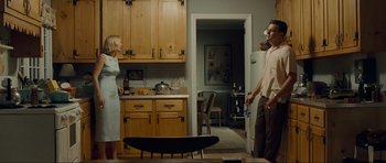 Movie still from “Revolutionary Road” (2008), directed by Sam Mendes – A man and a woman standing in a kitchen next to each other; Wide shot, Low angle