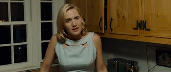 Movie still from “Revolutionary Road” (2008), directed by Sam Mendes – A woman with blonde hair wearing a blue dress; Medium shot, Over the shoulder angle