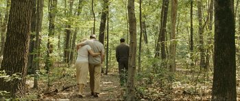 Movie still from “Revolutionary Road” (2008), directed by Sam Mendes – A man and a woman hugging in the woods; Wide shot, High angle