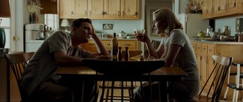 Movie still from “Revolutionary Road” (2008), directed by Sam Mendes – A man and a woman sitting at a table with drinks; Medium shot, Low angle