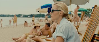 Movie still from “Revolutionary Road” (2008), directed by Sam Mendes – A group of people sitting on the beach eating food; Medium shot, Over the shoulder angle