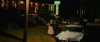 Movie still from “Revolutionary Road” (2008), directed by Sam Mendes – Two people walking in front of an elvis presley house at night; Wide shot, Over the shoulder angle