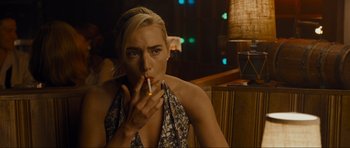 Movie still from “Revolutionary Road” (2008), directed by Sam Mendes – A woman sitting in front of a lamp smoking a cigarette; Close Up shot, Over the shoulder angle