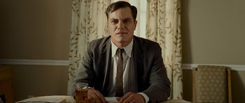Movie still from “Revolutionary Road” (2008), directed by Sam Mendes – A man sitting at a table with a glass of whiskey; Close Up shot, Low angle